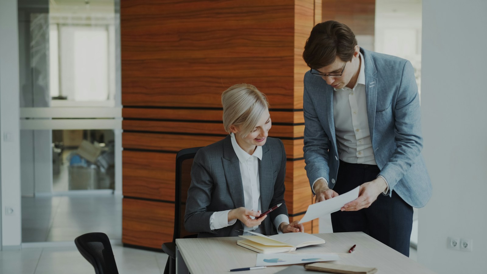 Two colleagues reviewing paperwork together at a desk